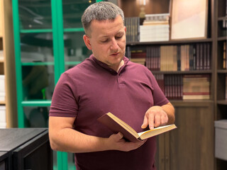Man reading a book in a modern library