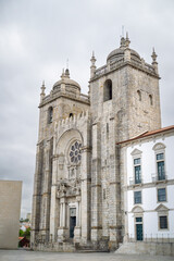 Historic Porto Cathedral façade rises against moody sky, Romanesque-Gothic stonework inviting heritage exploration, ideal for Portugal travel promos.