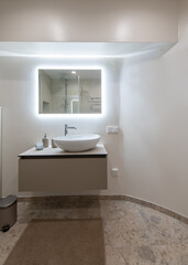 Modern Restroom Interior With Illuminated Vanity Mirror and Minimalist Decor