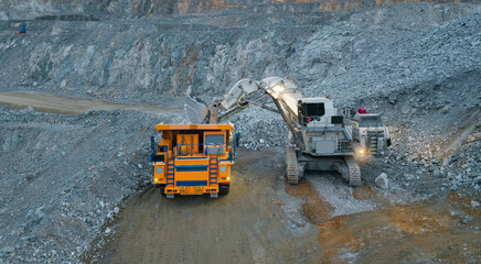 Heavy machinery in open pit mine with excavator working and yellow dump truck © Parilov