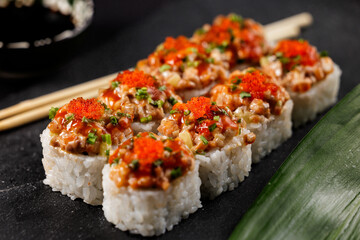closeup of delicious sushi rolls with tobiko and chopped vegetables