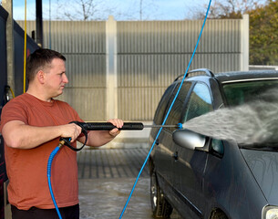 Man washing car with pressure washer