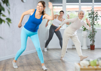 Obraz premium Happy different ages women learning swing steps at dance class