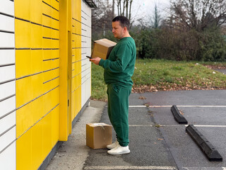 Man using smartphone by yellow locker with package