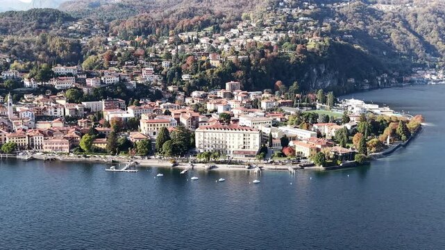 Aerial drone view over Menaggio town and mountains

High-altitude drone shot showing Menaggio&rsquo;s colorful lakeside buildings climbing the hillside with mountains in the background.

