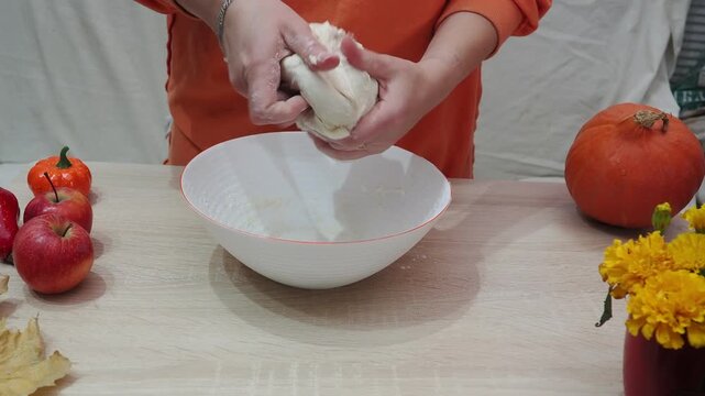 A girl is making apple pie at home. Autumn fall baking background with pumpkins, apples, nuts, food ingredients and seasonal spices. Cooking pumpkin or apple pie for Thanksgiving and autumn holidays, 