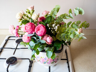 bouquet of fresh peony flowers in stovetop kettle