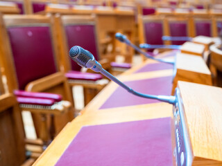 microphone closeup at desks in conference hall