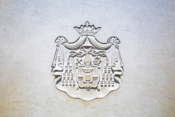 classic bas-relief coat of arms carved into the stone walls of a cathedral.