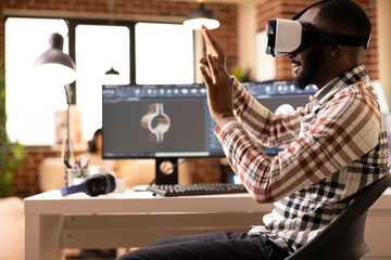 African american freelance developer immersed in VR, prototyping 3D clamp model. Black male engineer using computer aided design tools and virtual reality headset to craft precision product design.