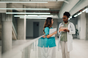 Diverse doctors collaborating in modern hospital corridor