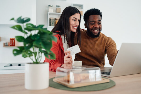 Happy multiracial couple online shopping with credit card - Powered by Adobe
