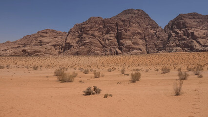 A trip to Wadi Rum desert in Jordan. Beautiful 
african travel photo. Sandy landscapes, mountains, rocks,
dunes, and nature. Summer vacation in arab country.
Moon Valley. Martian desert.