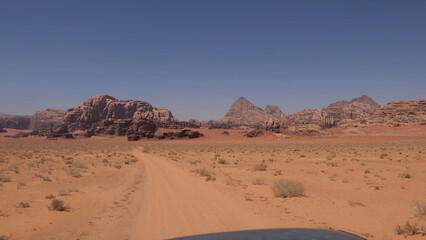 Fototapeta premium A trip to Wadi Rum desert in Jordan. Beautiful african travel photo. Sandy landscapes, mountains, rocks, dunes, and nature. Summer vacation in arab country. Moon Valley. Martian desert.