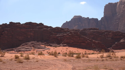 Fototapeta premium A trip to Wadi Rum desert in Jordan. Beautiful african travel photo. Sandy landscapes, mountains, rocks, dunes, and nature. Summer vacation in arab country. Moon Valley. Martian desert.
