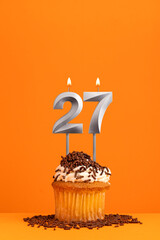 Number 27 candle - Birthday card design in orange background. Cupcake