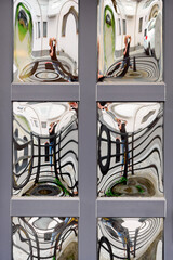 A wooden door panel with square curved mirrored glass inserts