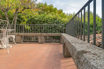 Textured resin dining table in a patio with a volcanic stone facade and shade