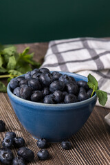 The photograph captures the precise moment several blueberries fall onto the wood, creating a dynamic composition full of spontaneous movement
