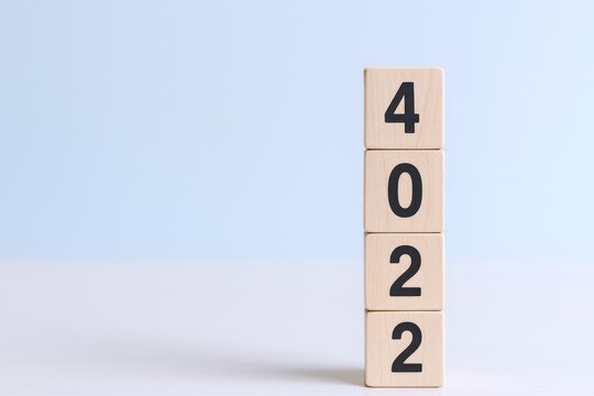 Wooden Blocks Displaying the Numbers 4022 Against a Soft Blue Background, Highlighting Numerical Sequencing