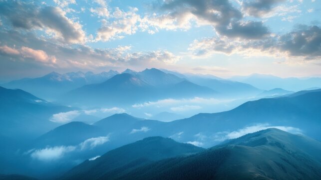 Majestic Mountain Range Under a Bright Cloudy Sky with Misty Valleys and Blue Hues