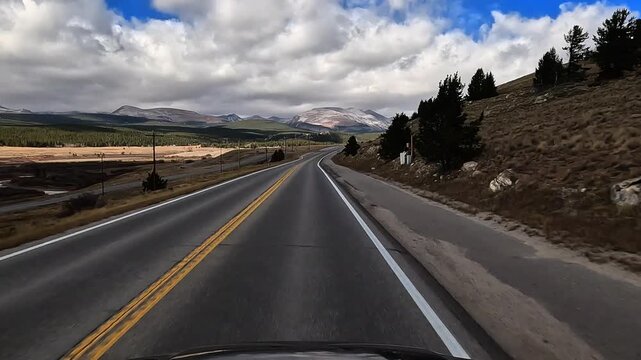 Drive along Colorado Highway 9 north in late fall early winter through rural high elevation area with snowy mountains in the distance