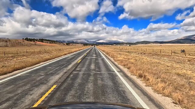 Drive along Colorado Highway 9 north in late fall early winter through rural high elevation area with snowy mountains in the distance