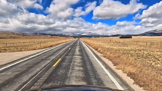 Drive along Colorado Highway 9 north in late fall early winter through rural high elevation area with snowy mountains in the distance