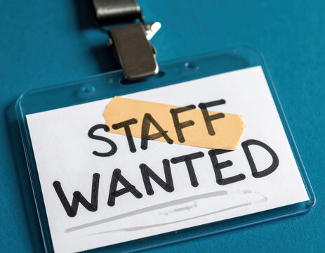 Staff wanted sign with bandage symbolizes quick fix for labor market shortages. This concept represents recruitment challenges and urgent need for new employees
