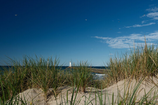 Sand Dunes, grasses and The Sodus Point Lighhtouse and pier on Lake Ontario New York State on a perfect afternoon