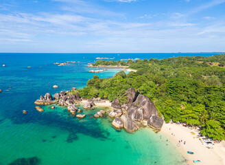 Stunning aerial view of Tanjung Tinggi Beach in Belitung, Indonesia. Known as 'Laskar Pelangi Beach', this popular destination features giant granite boulders and clear turquoise water.