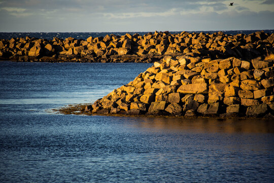 Rocky shoreline with sunlight and calm water
