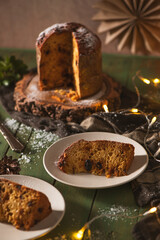 Two Slices of Panettone on Plates Against a Moody Background