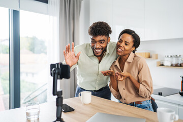 Happy couple enjoying video call in kitchen