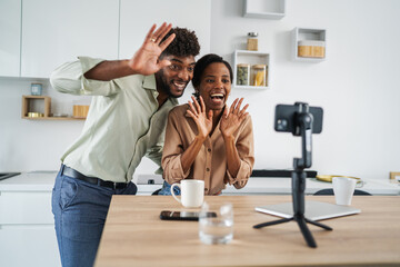 Happy african american couple v-logging from home, streaming online content
