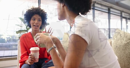 Chatting pair in red blouse and white top sitting on sofa, holding disposable cup, green mug © vectorfusionart