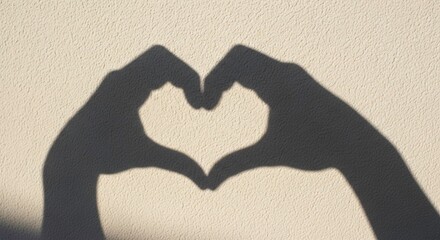 Shadow of hands forming a heart shape on a textured wall
