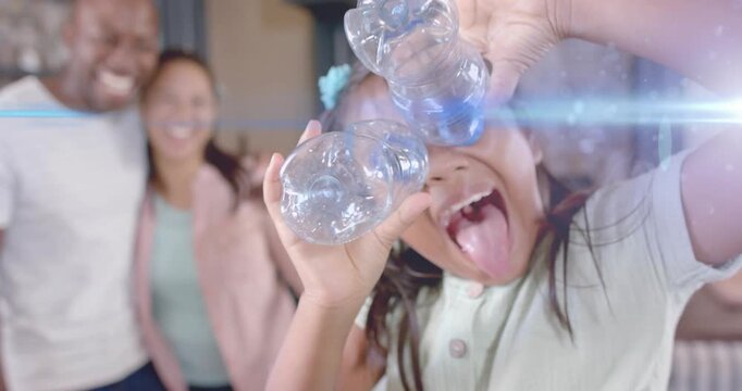 Child bringing bottles to face, peering, sticking tongue, lens-flare framing education for parents