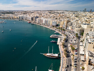 Naklejka premium Aerial view of Sliema seafront and city skyline. Coastal urban architecture and harbour of Malta with boats.