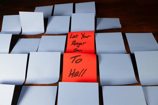 Red sticky note in a field of blue sticky notes reading "Let Your Anger Go to Hell"