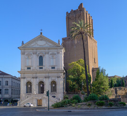 Facade of Santa Caterina a Magnanapoli Church, set against the towering medieval Torre delle Milizie in Rome, Italy