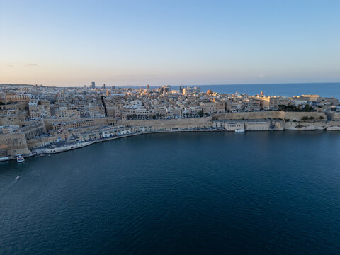 Malta Valletta Grand Harbour entrance with historic Fort St Elmo and breakwater aerial drone view.

