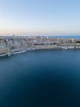 Malta Valletta Grand Harbour entrance with historic Fort St Elmo and breakwater aerial drone view.
