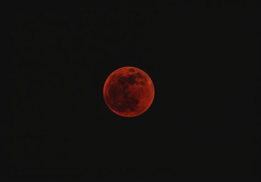 Striking view of a perfectly spherical blood moon during a total lunar eclipse against a black night sky - Powered by Adobe