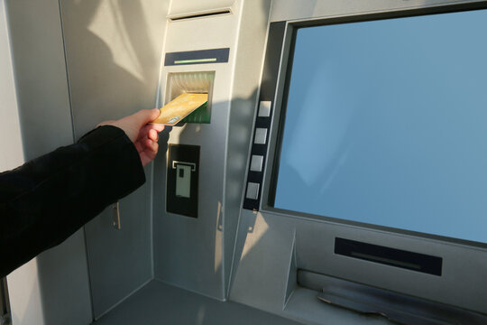 Woman with bank card using modern cash machine, closeup. ATM