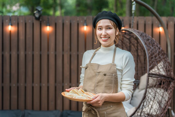 A young Asian woman wearing an apron working in a stylish cafe