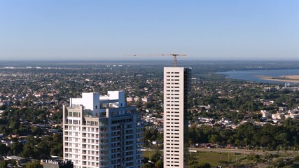 Drone footage of modern high-rise buildings dominating the urban skyline of Corrientes City surrounded by residential areas.