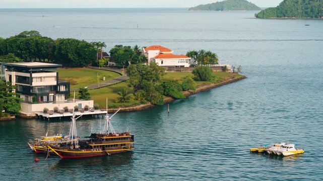 Scenic aerial view of Sutera residency luxury waterfront buildings and docked boats with lush green Gaya island in the background in Kota Kinabalu Sabah Malaysia