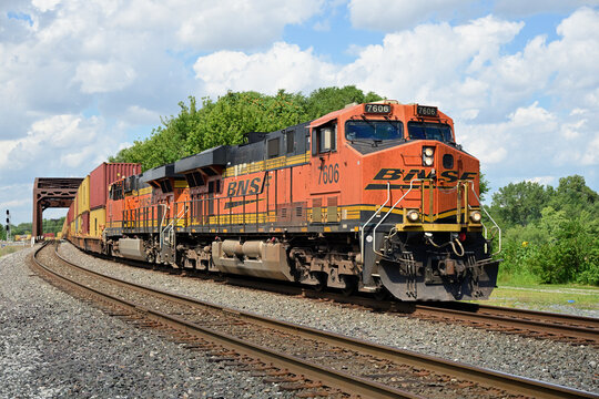 With its train spread out behind, Burlington Northern Santa Fe locomotives lead an intermodal freight train across a bridge and through south suburban Chicago.