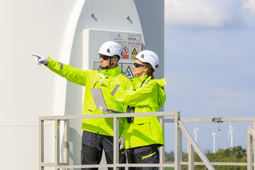 Engineer team man and woman working together survey plan construction wind turbine sustainable...